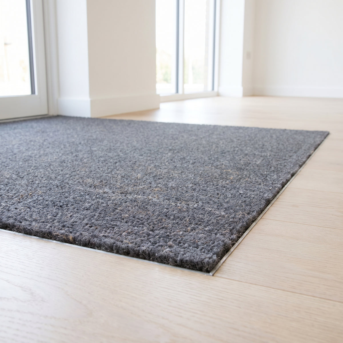Grey 17mm coir entrance matting in a mat well at a bright clinic entrance with oak floor