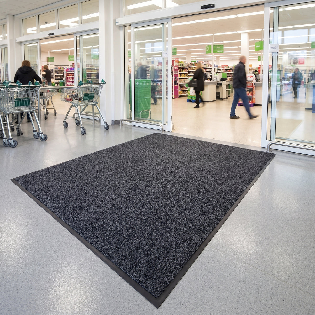 Dark Grey commercial made to measure entrance mat cut to size inside the automatic doors of a busy UK supermarket