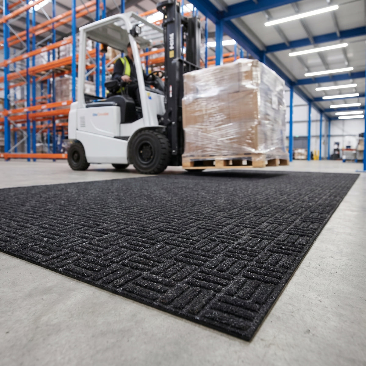 Charcoal forklift truck mat tiles at the entrance lane of a modern distribution centre with a forklift carrying a pallet