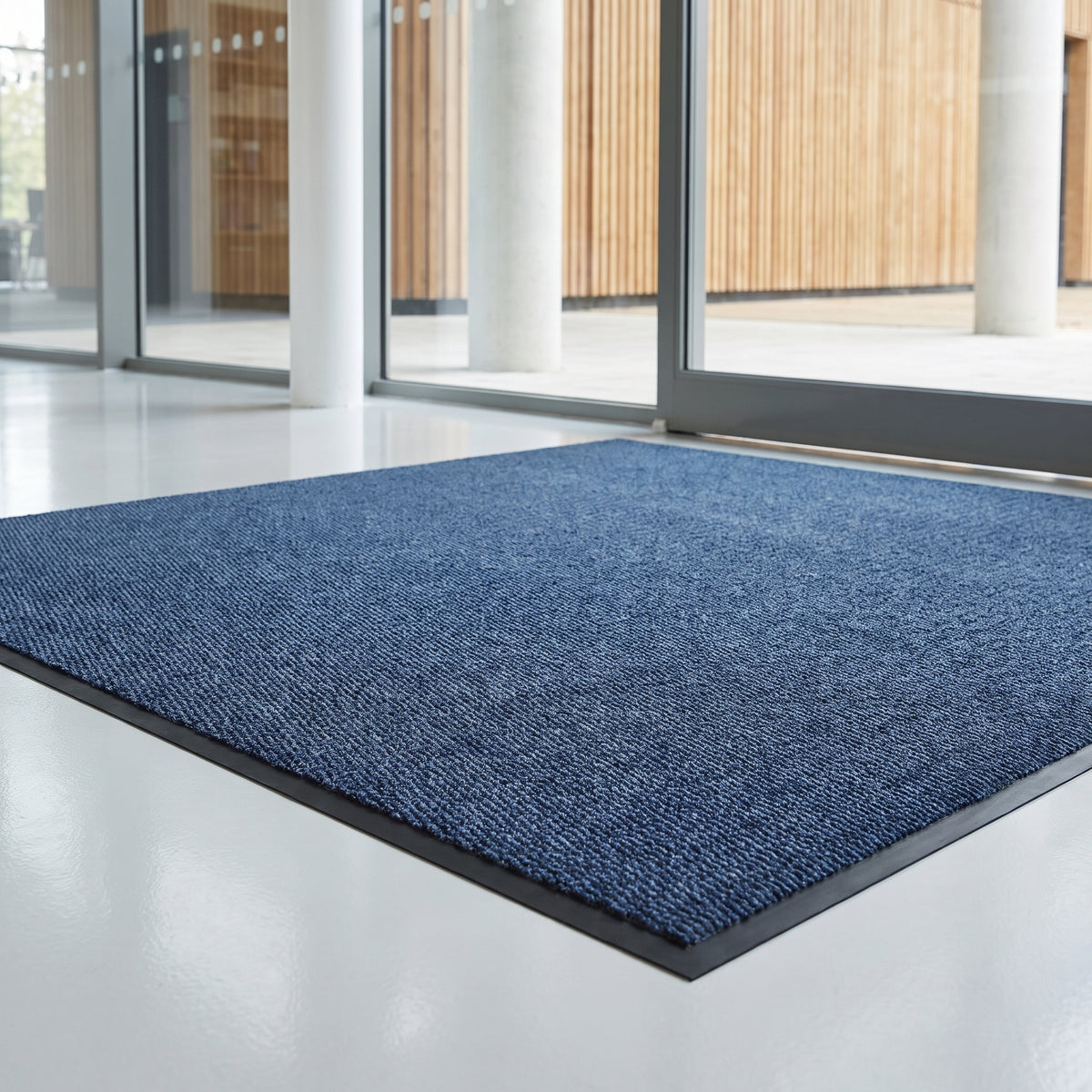 Blue low-profile entrance mat at a university atrium entrance