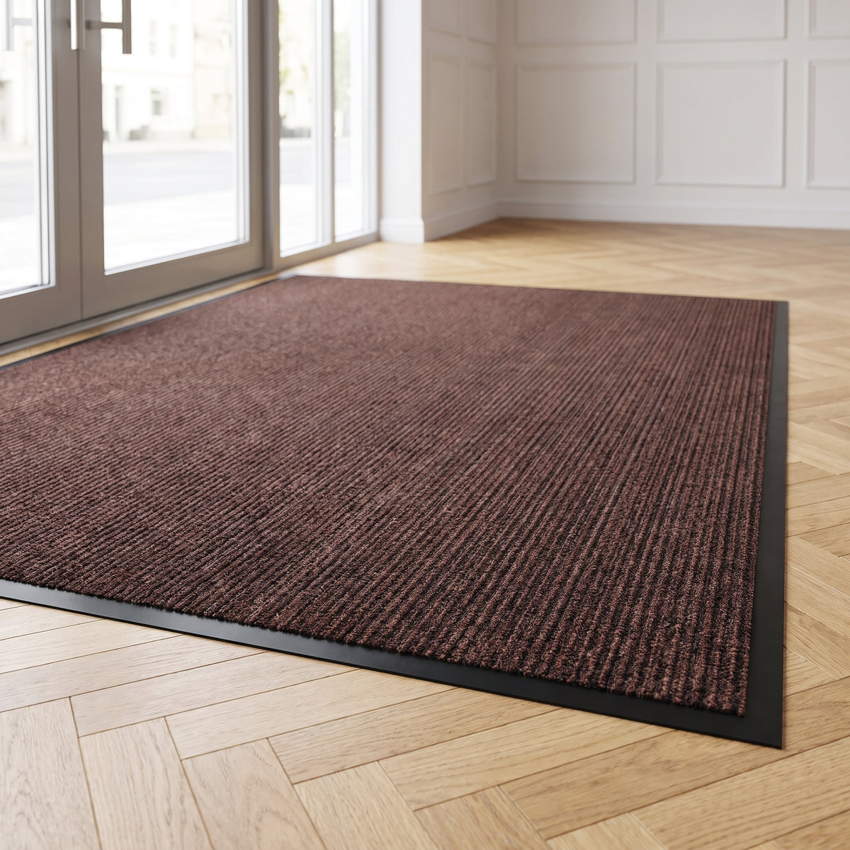 Brown low-profile entrance mat on parquet at a boutique hotel entrance in daylight