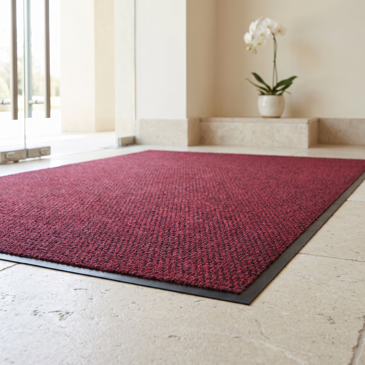 Red low-profile entrance mat at a luxury spa entrance in daylight