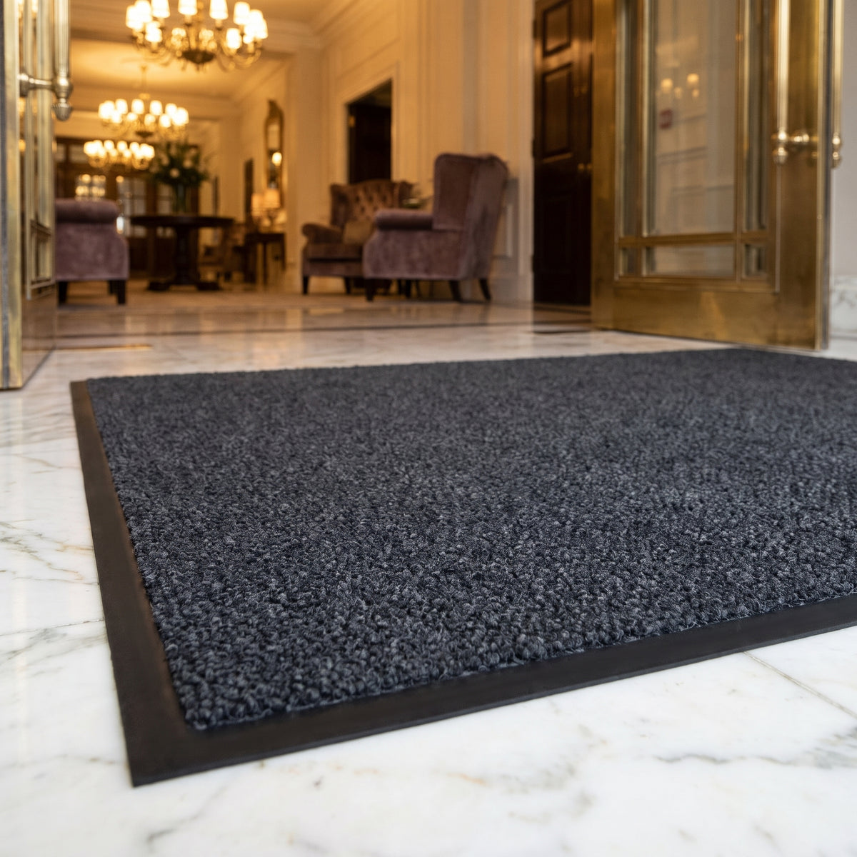 Close-up of Dark Grey luxury made to measure entrance mat plush pile and rubber border at a five-star hotel lobby entrance on marble
