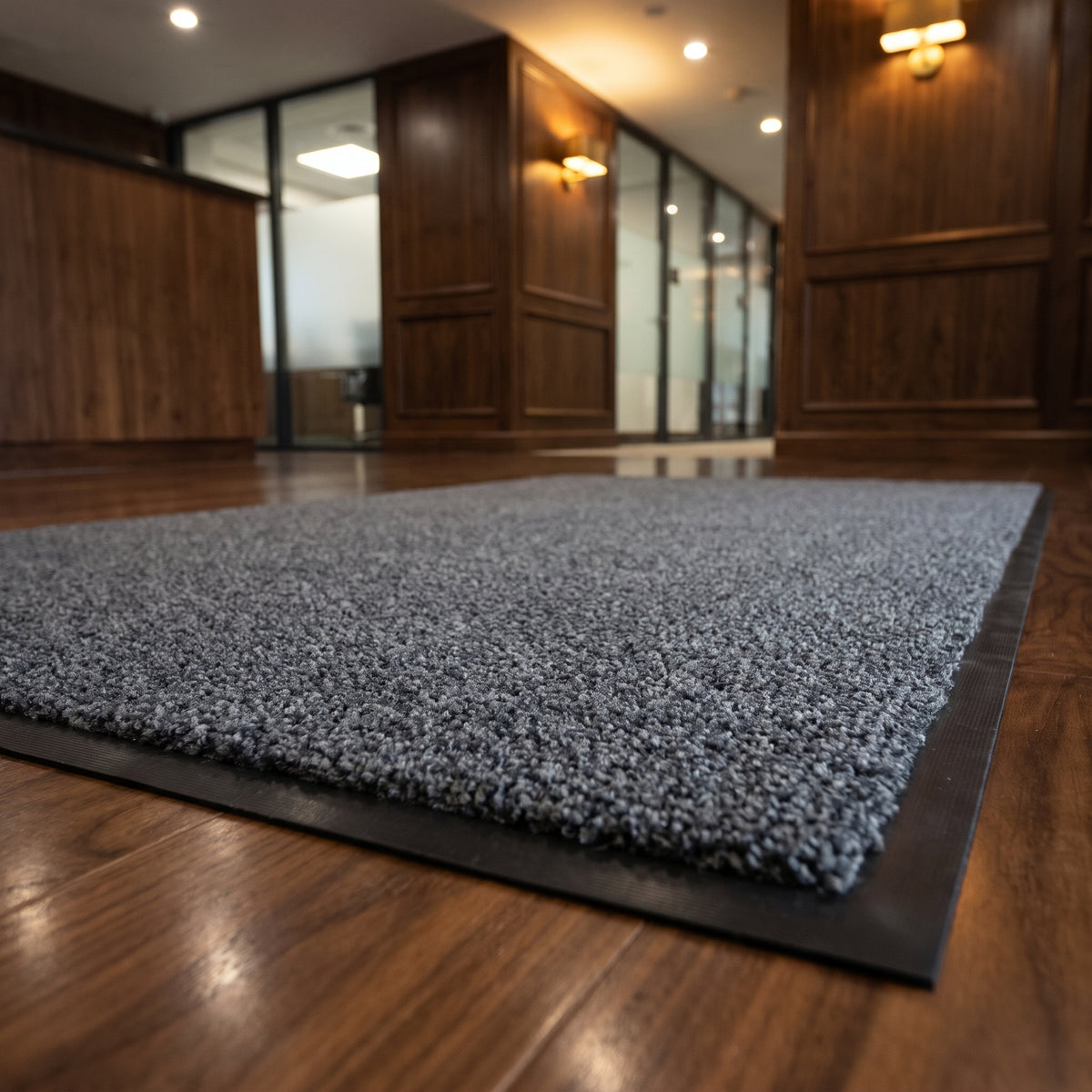 Close-up of Granite luxury made to measure entrance mat in a law firm reception on walnut flooring