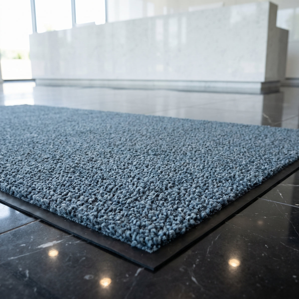 Close-up of Slate Grey luxury made to measure entrance mat in a corporate headquarters reception on black marble