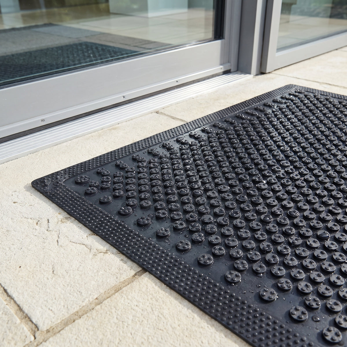 Close-up of rubber scraper buttons, textured border and 5mm low-profile edge with water droplets