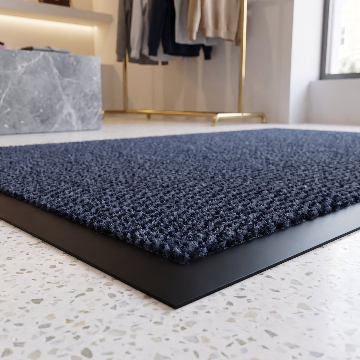 Close-up of blue Slimline entrance mat pile and border inside a designer boutique on terrazzo