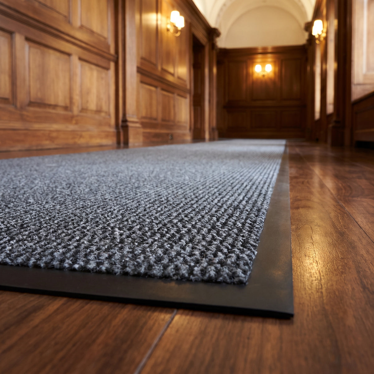 Close-up of custom length grey Slimline runner mat along a walnut-panelled executive corridor