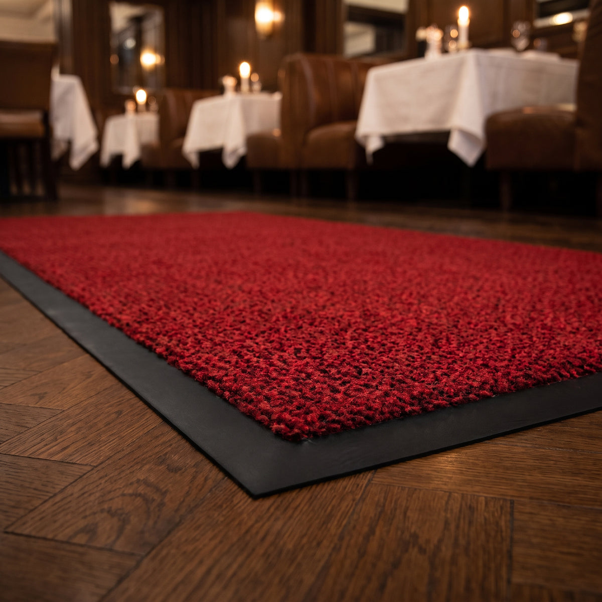 Close-up of red Slimline entrance mat pile and border at a fine dining restaurant entrance on parquet