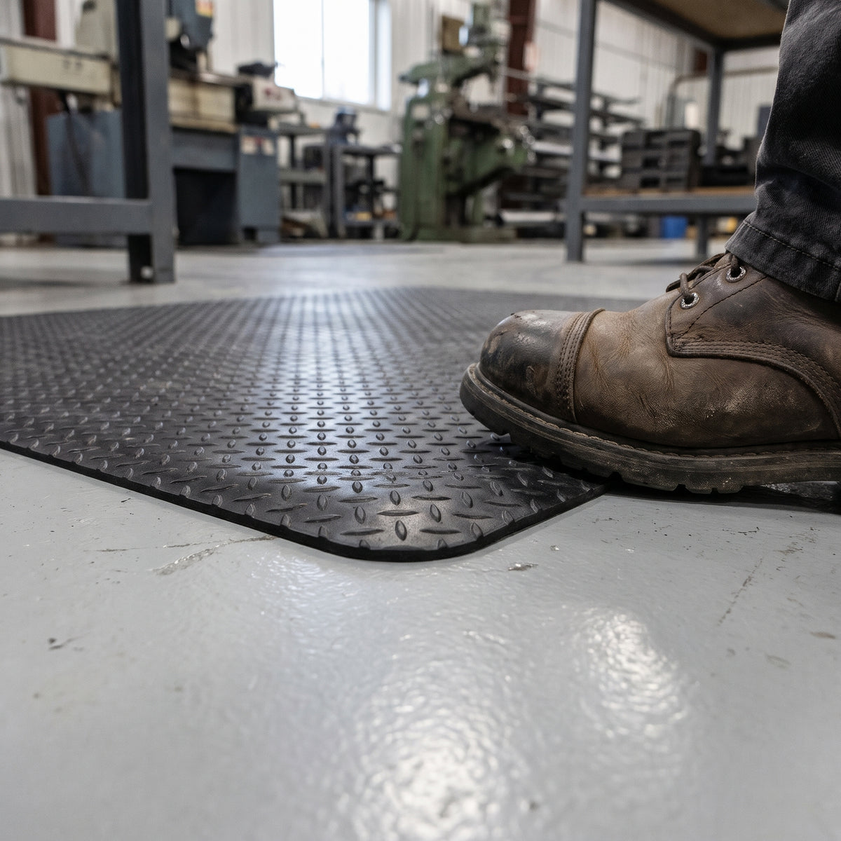 Close-up of the bevelled edge and diamond plate surface of the 14mm vinyl-top anti-fatigue mat
