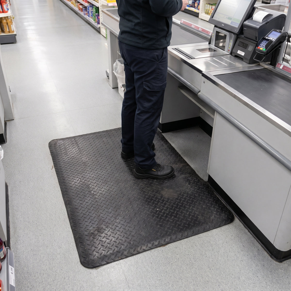 Black 14mm anti-fatigue mat behind a supermarket checkout till for cashier comfort